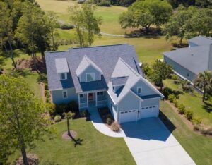 Low aerial view of house with new roof and golf course behind.